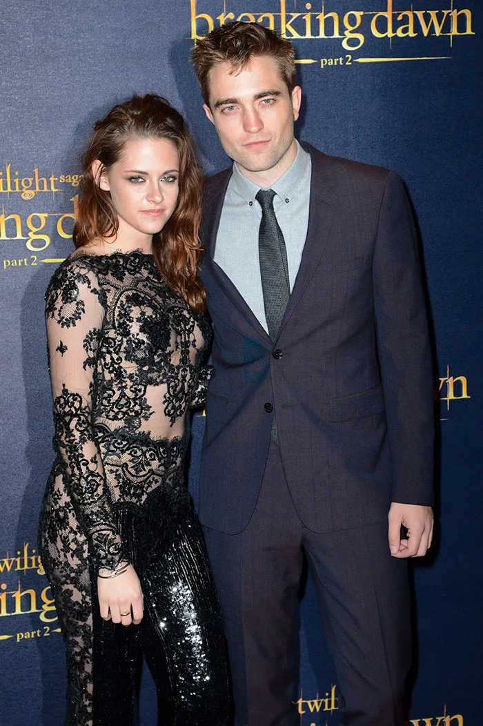 Actors posing together at a movie premiere, representing celebrities who fell in love while acting together.