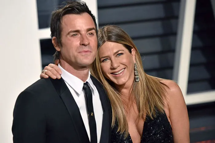 Two celebrities posing together at a formal event, representing celebrities who fell in love while acting together.