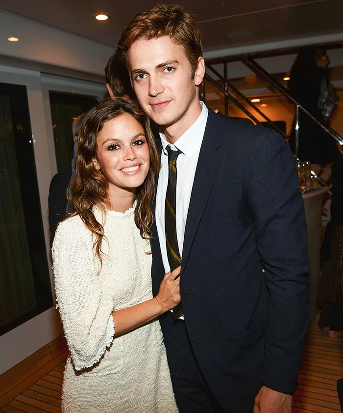 Young celebrity couple posing together at an event, showcasing love and connection while acting together on screen.