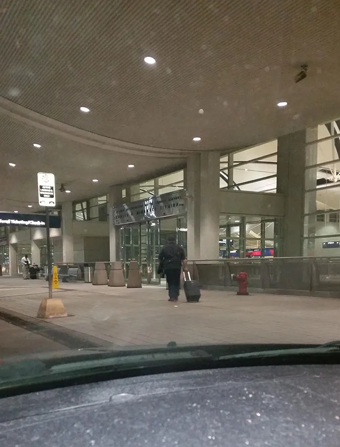 Man walking towards the entrance of an airport 
