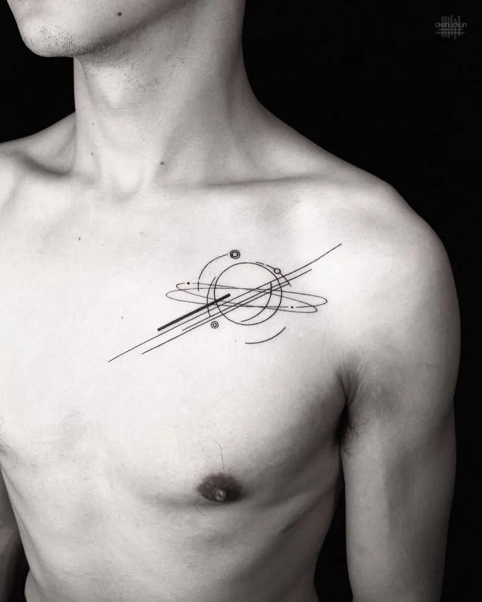 Geometric tattoo design by Turkish artist Okan Uçkun on a person's upper chest, featuring circles and lines.