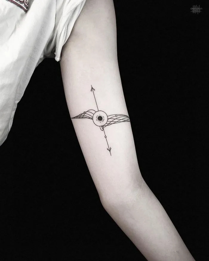 Geometric tattoo by Turkish artist Okan Uçkun, featuring intricate line design on a person's arm.
