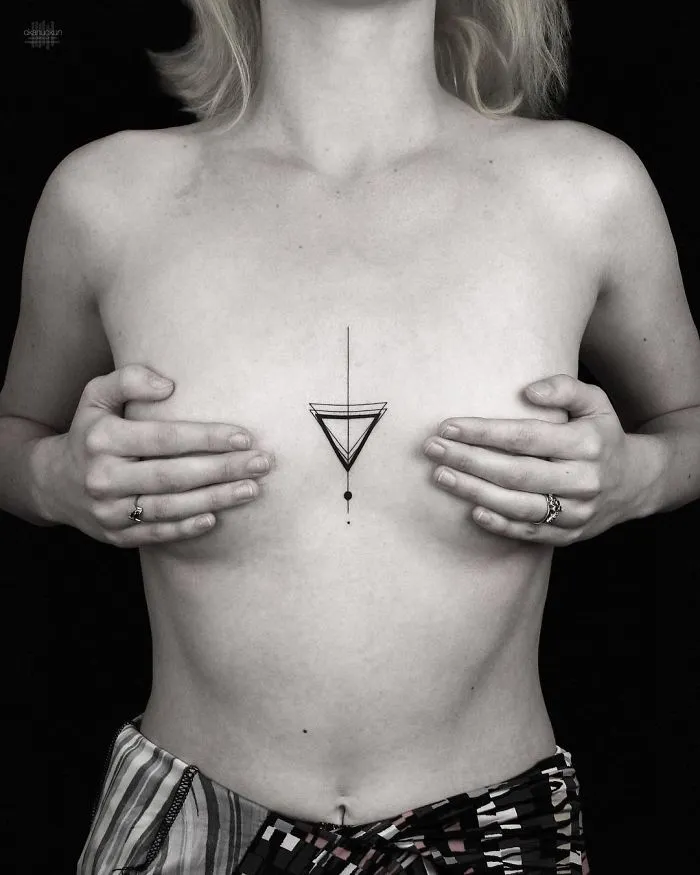 Person showcasing a geometric tattoo on their chest by Turkish artist.