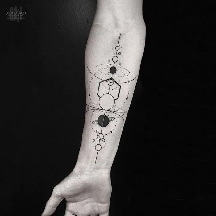 Geometric tattoo featuring circles and lines on a forearm by Turkish artist Okan Uçkun.