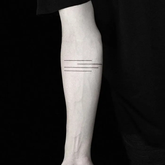 Minimalist geometric tattoo by Turkish artist on forearm, featuring parallel lines.