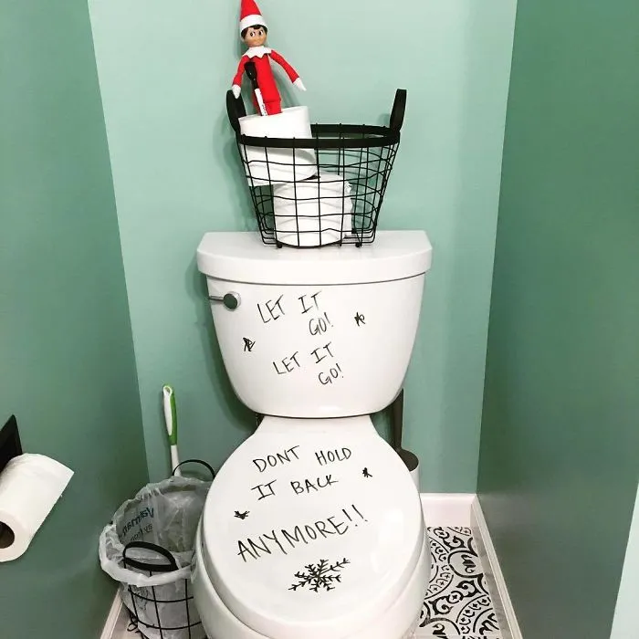 Elf On The Shelf on toilet tank with Frozen theme message let it go don’t hold it back for playful mischief idea.