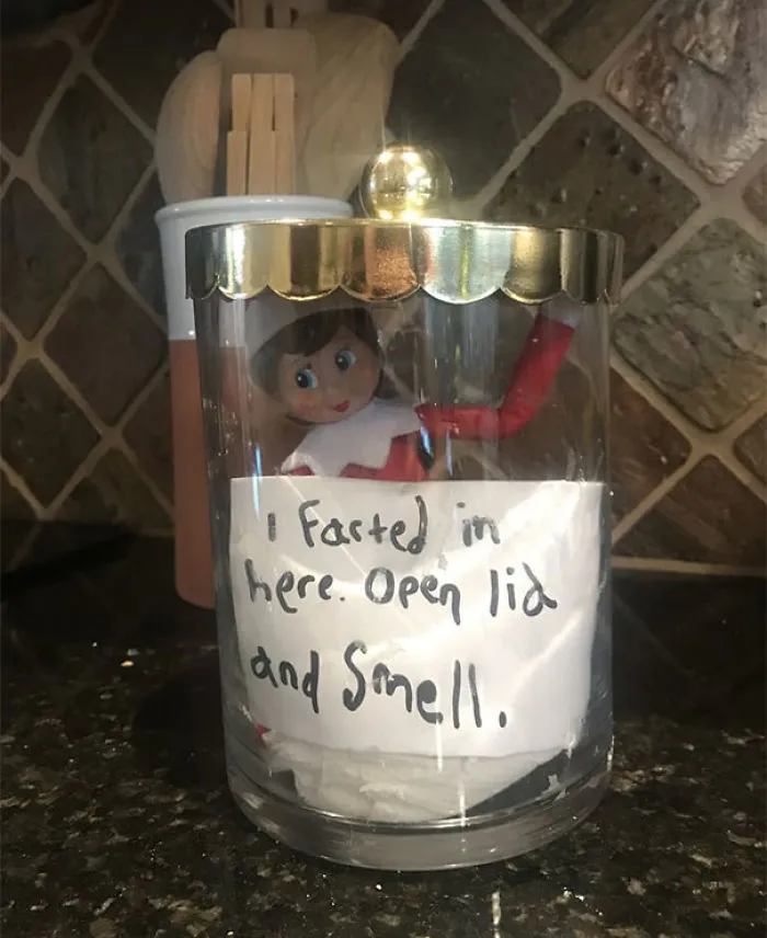 Elf On The Shelf inside a glass jar with a note prank saying I farted in here open lid and smell for playful mischief.