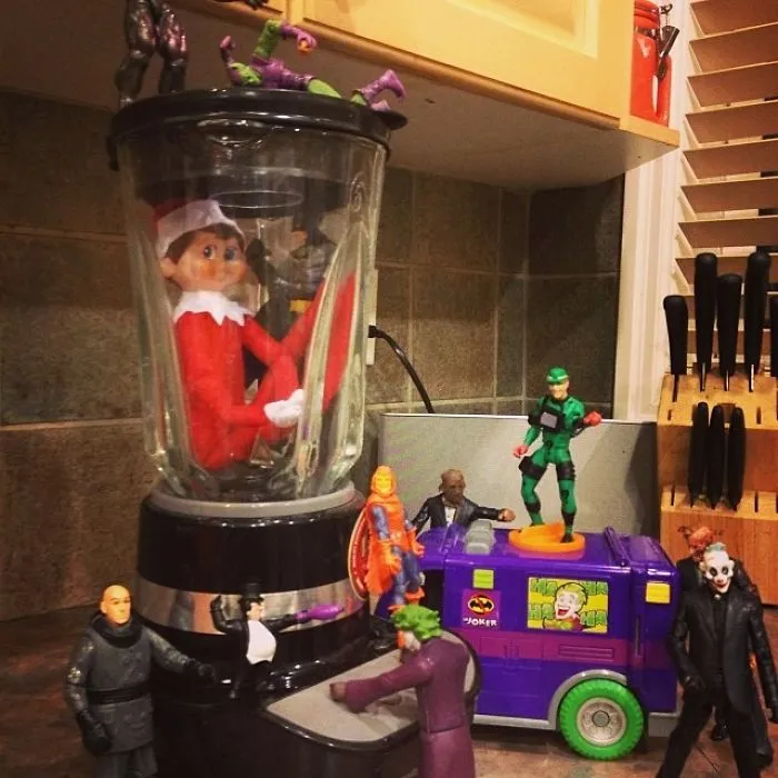 Elf On The Shelf trapped in a blender surrounded by villain action figures for a mischievous holiday scene.