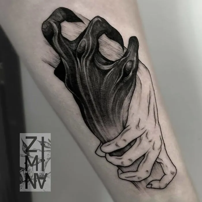 Unique tattoo design of hands grasping dark, abstract form on forearm for ink lovers.