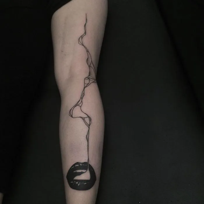 Abstract tattoo of lips with a swirling line on an arm, ideal for ink lovers.