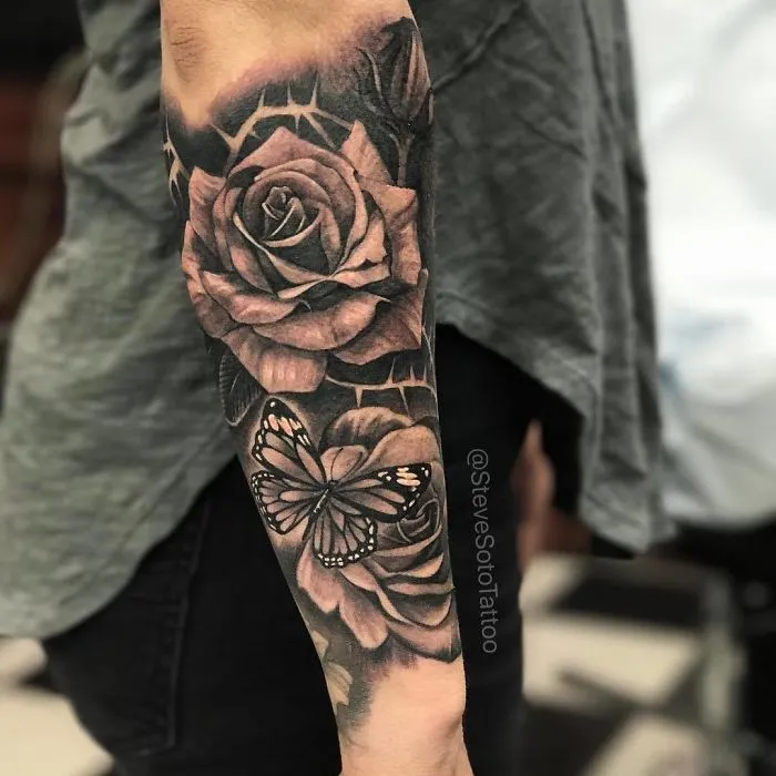 Arm tattoo featuring a detailed rose and butterfly design, perfect inspiration for ink lovers.