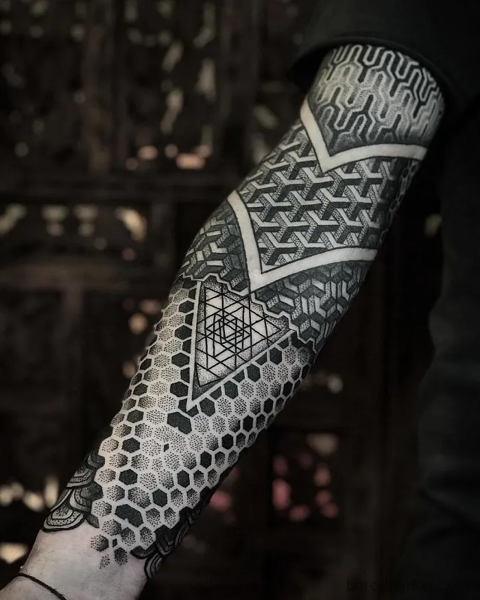 Geometric tattoo sleeve with intricate black and grey patterns for ink lovers.