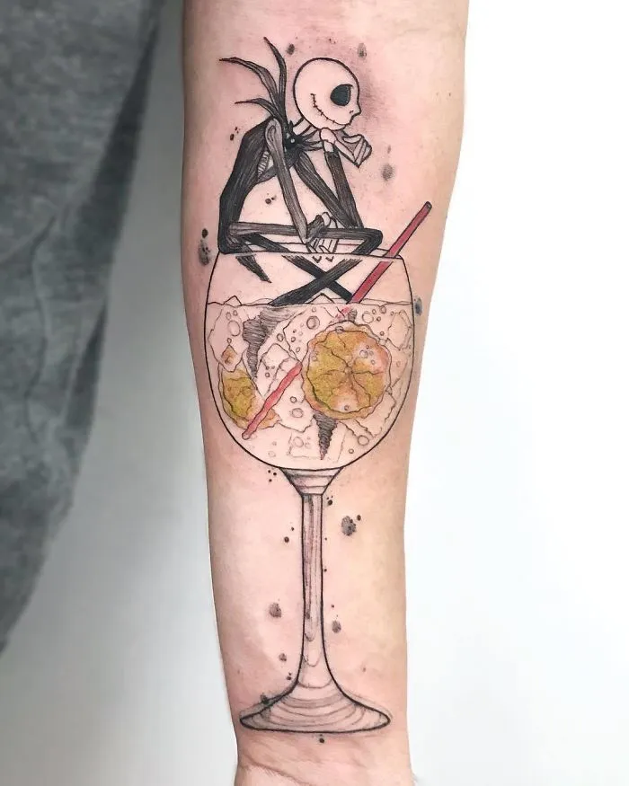 Minimalist tattoo of a skeleton sitting in a wine glass, perfect for ink lovers seeking unique ideas.