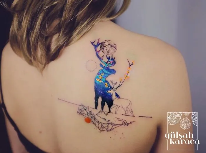 Colorful deer tattoo on a woman's back, featuring a celestial design with vivid details for ink lovers.