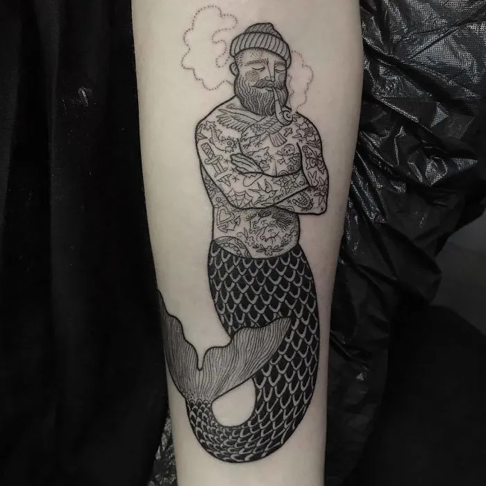 Mermaid tattoo design featuring a bearded sailor with crossed arms and detailed body artwork.