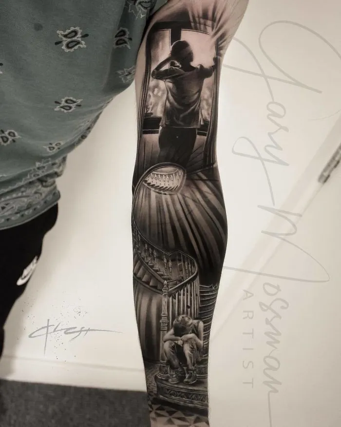 A detailed black and gray sleeve tattoo featuring a staircase and a person in contemplation.