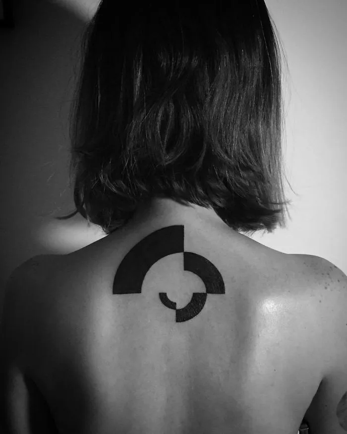 Back view of a person with a minimalist geometric tattoo, ideal inspiration for ink lovers.