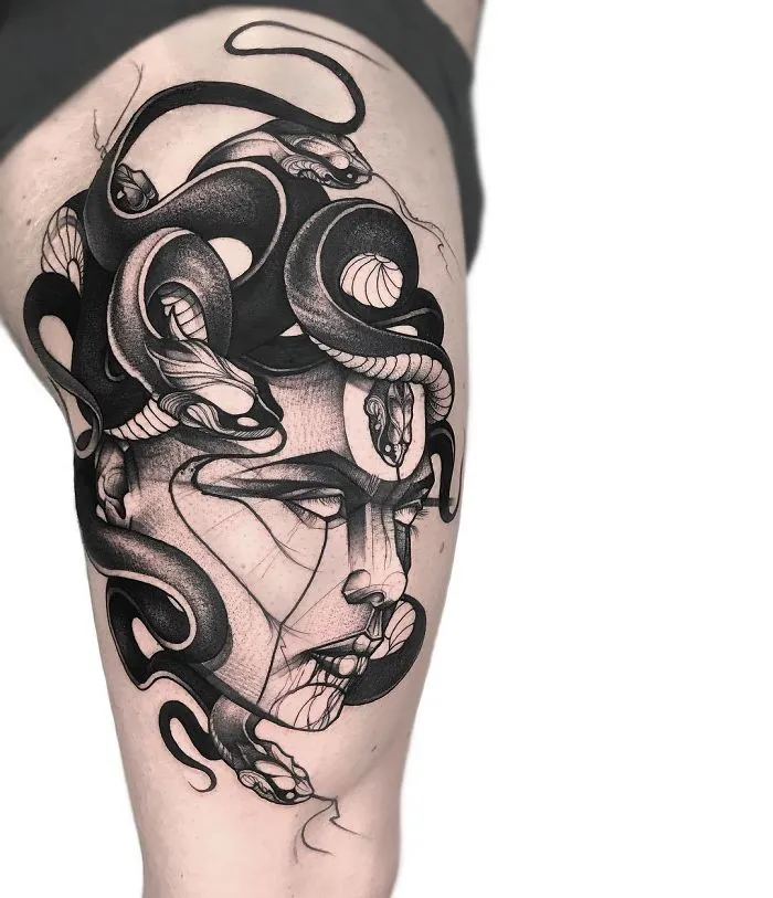 Black and grey Medusa tattoo on thigh, featuring detailed snakes and geometric elements for ink lovers.