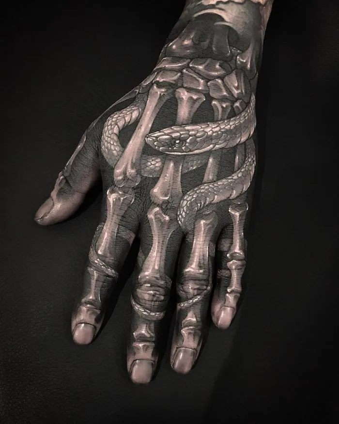 Hand with a skeleton and snake tattoo design for ink lovers.
