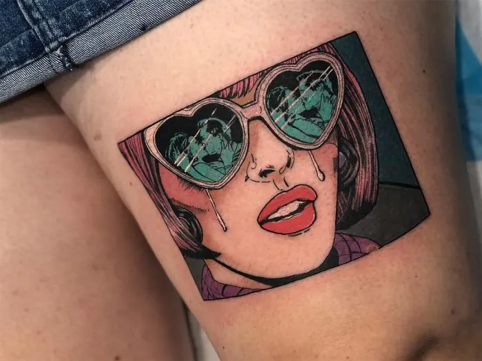 Pop art tattoo depicting a woman in heart-shaped glasses on thigh.