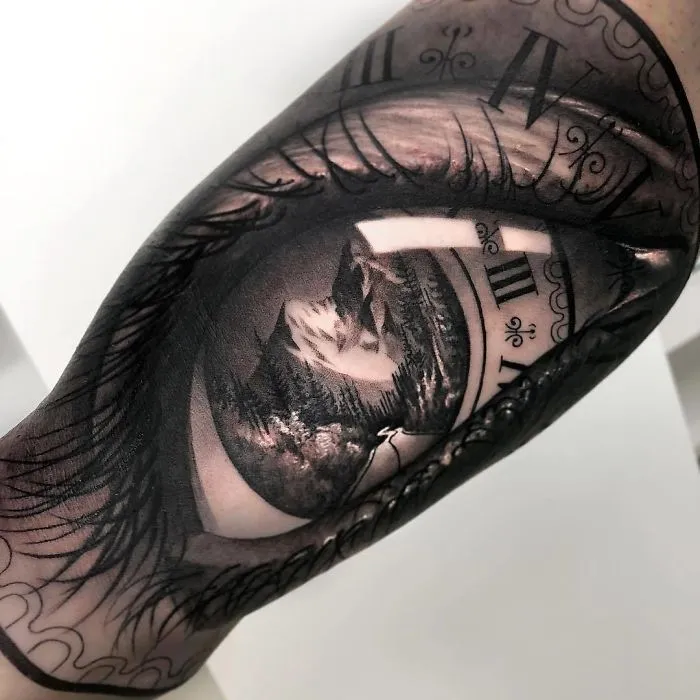 Intricate tattoo design on arm featuring a landscape within a clock, showcasing creative tattoo ideas.