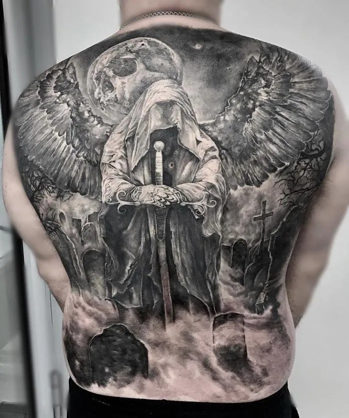 Full back tattoo featuring a dark winged figure with a skull background, perfect for ink lover inspiration.