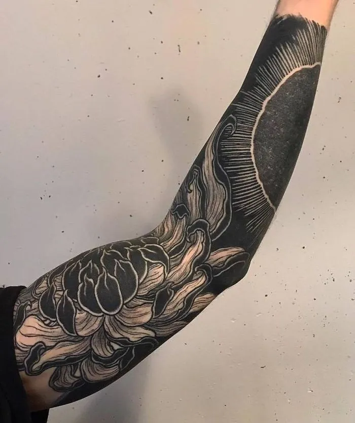 Arm with detailed floral sleeve tattoo, showcasing creative tattoo ideas for ink lovers.