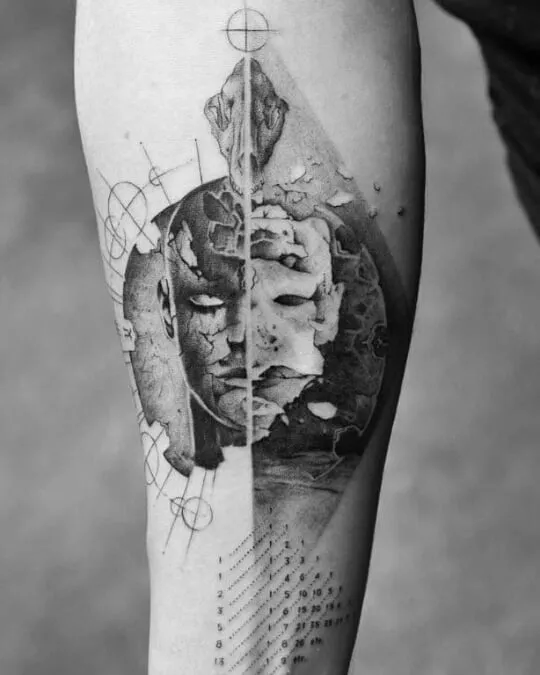 Abstract geometric tattoo on forearm, featuring a split face design, ideal for every ink lover.