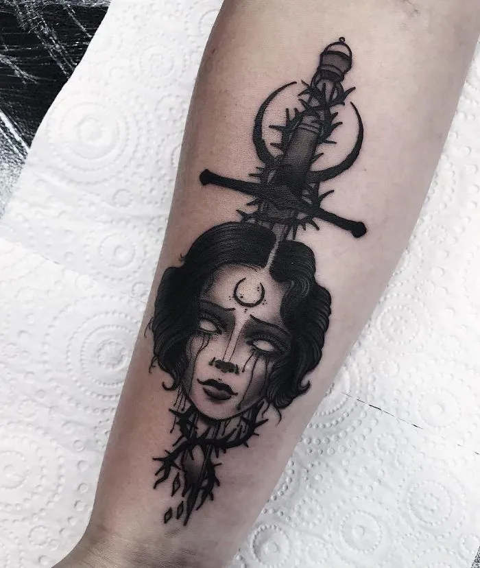 "Unique tattoo design of a woman's face with a sword and crescent moon, ideal for ink lovers."