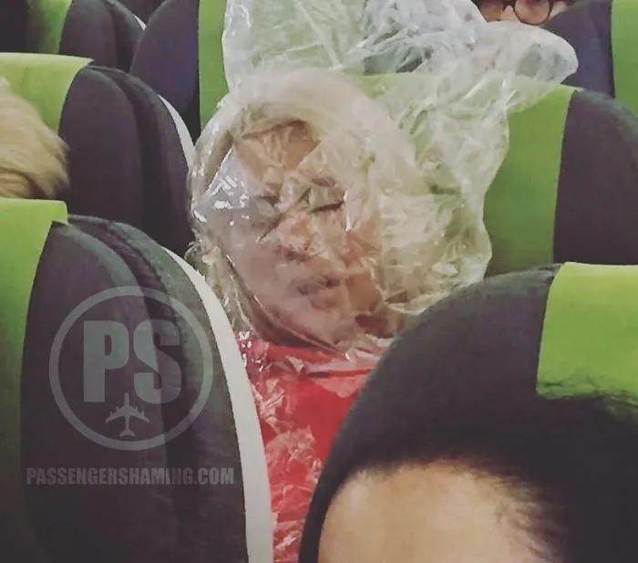 Esta pasajera tenía frío, así que se puso en la cabeza la bolsa de plástico de la manta para calentarse... un premio Darwin para ella