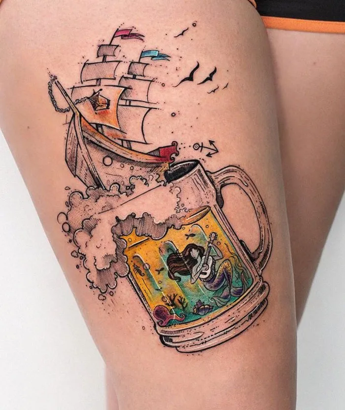 Tattoo idea featuring a ship sailing on a foamy beer mug with a mermaid inside, ideal for ink lovers.