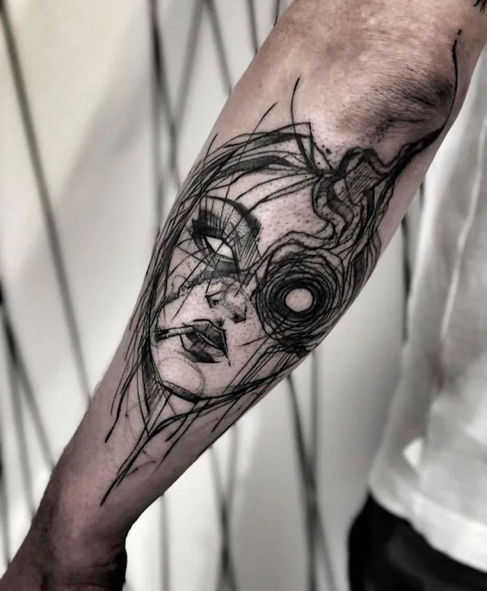 Unique abstract tattoo on forearm featuring a woman's face with artistic line design.