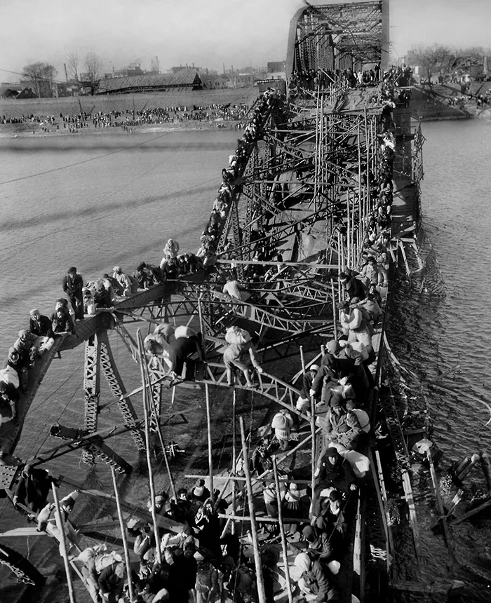 Refugiados cruzando un puente roto en Corea