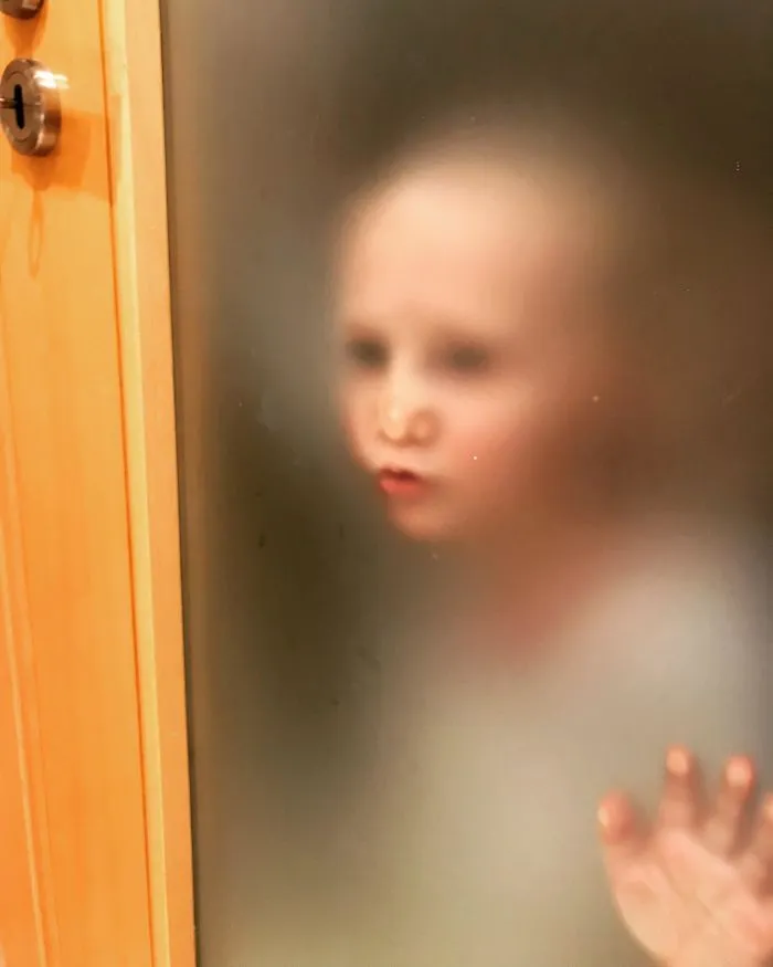 El piso de Airbnb tiene esta puerta en el baño y mi hijo pequeño estaba esperando impaciente a que saliera