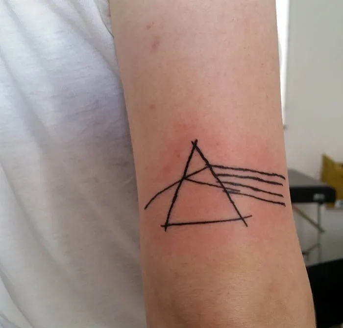 Abstract tattoo design with geometric lines on an arm by a popular tattoo artist known for unique styles.