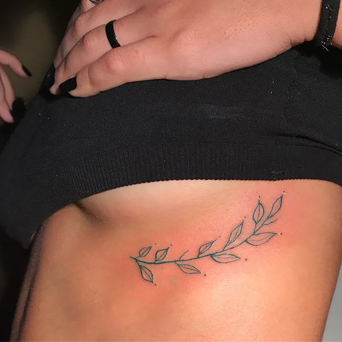 Minimalist leaf tattoo designed by a unique tattoo artist known for abstract styles.