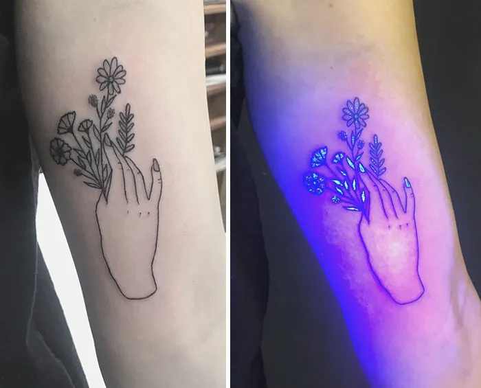 UV tattoo of a hand holding flowers, glowing under blacklight to showcase intricate design details.