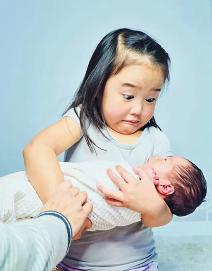 La reacción de mi hija al sostener a su hermanita. Pesa más que las muñecas con las que practicaba