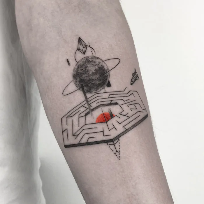 Geometric tattoo featuring a planet and maze design on an arm, symbolizing life events.
