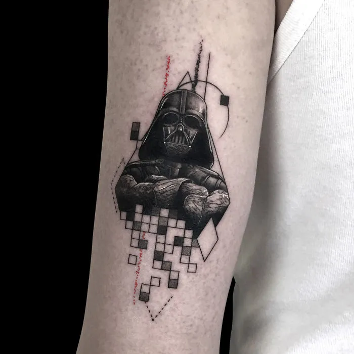 Geometric tattoo design featuring iconic sci-fi helmet with abstract shapes and lines on arm.