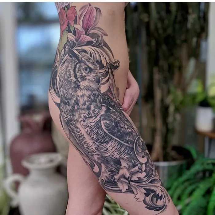 Detailed leg sleeve tattoo featuring an owl and floral designs.