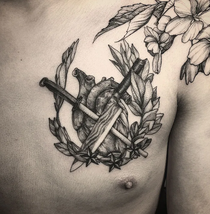Chest tattoo featuring a realistic heart with laurel leaves and swords, expressing a bold ink design.