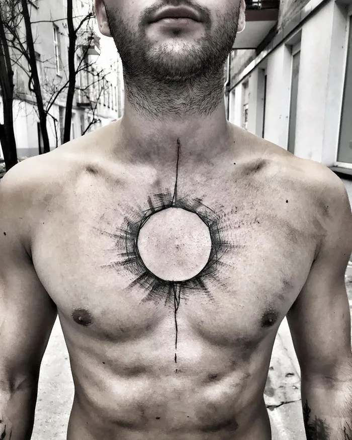 Man with a detailed geometric chest tattoo in an urban setting.