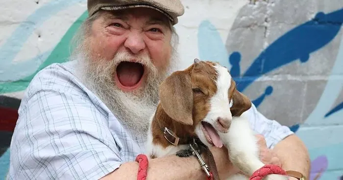 Son Shares Heartwarming Pictures Of His Dad Holding A 3 Weeks Old Baby Goat, And It's Priceless