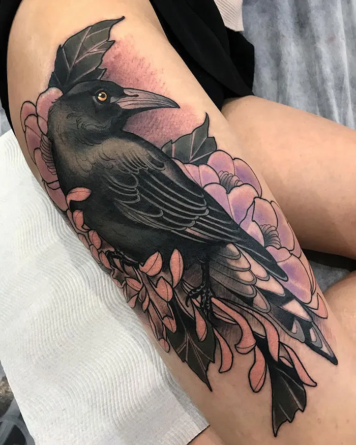 Black raven leg sleeve tattoo with pink flowers and green leaves.