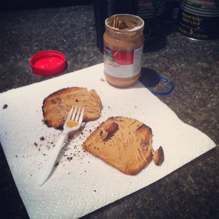 Burnt Loaf Heels With Generic Brand Peanut Butter, Spread With A Plastic Fork. Prepared In The Kitchen, Eaten, While Frowning, At The Desk