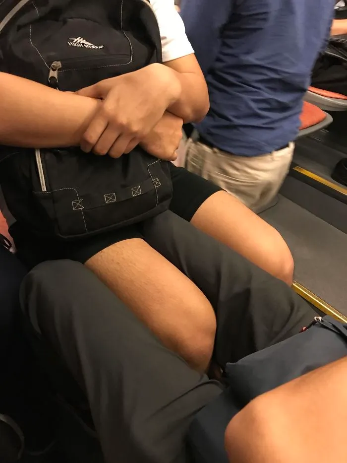 Two tall people sitting closely on public transport, highlighting common struggles of tall people in everyday situations.