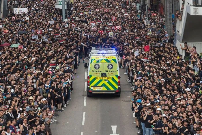 Manifestantes apartándose para dejar pasar una ambulancia