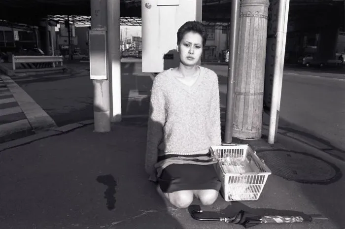 Woman Kneeling In Street. 1980