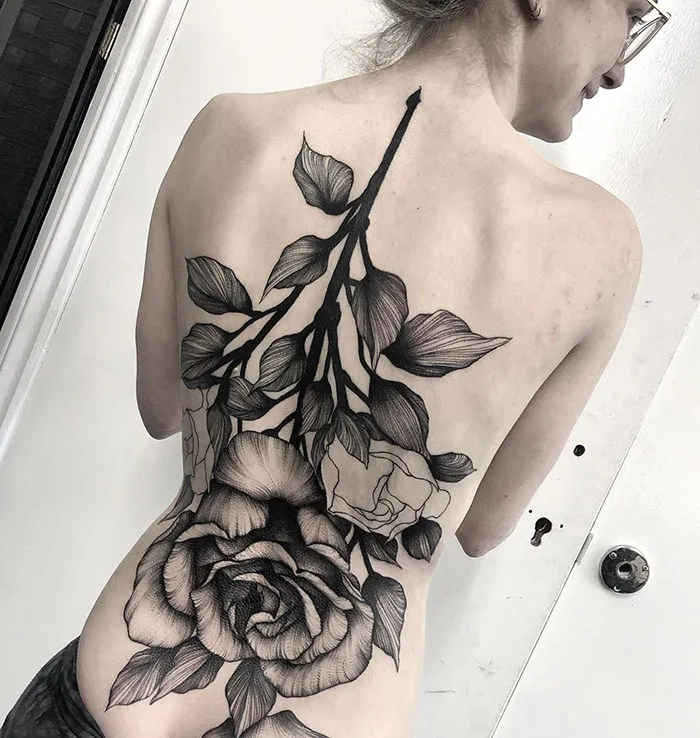 Intricate floral back tattoo design featuring leaves and roses.